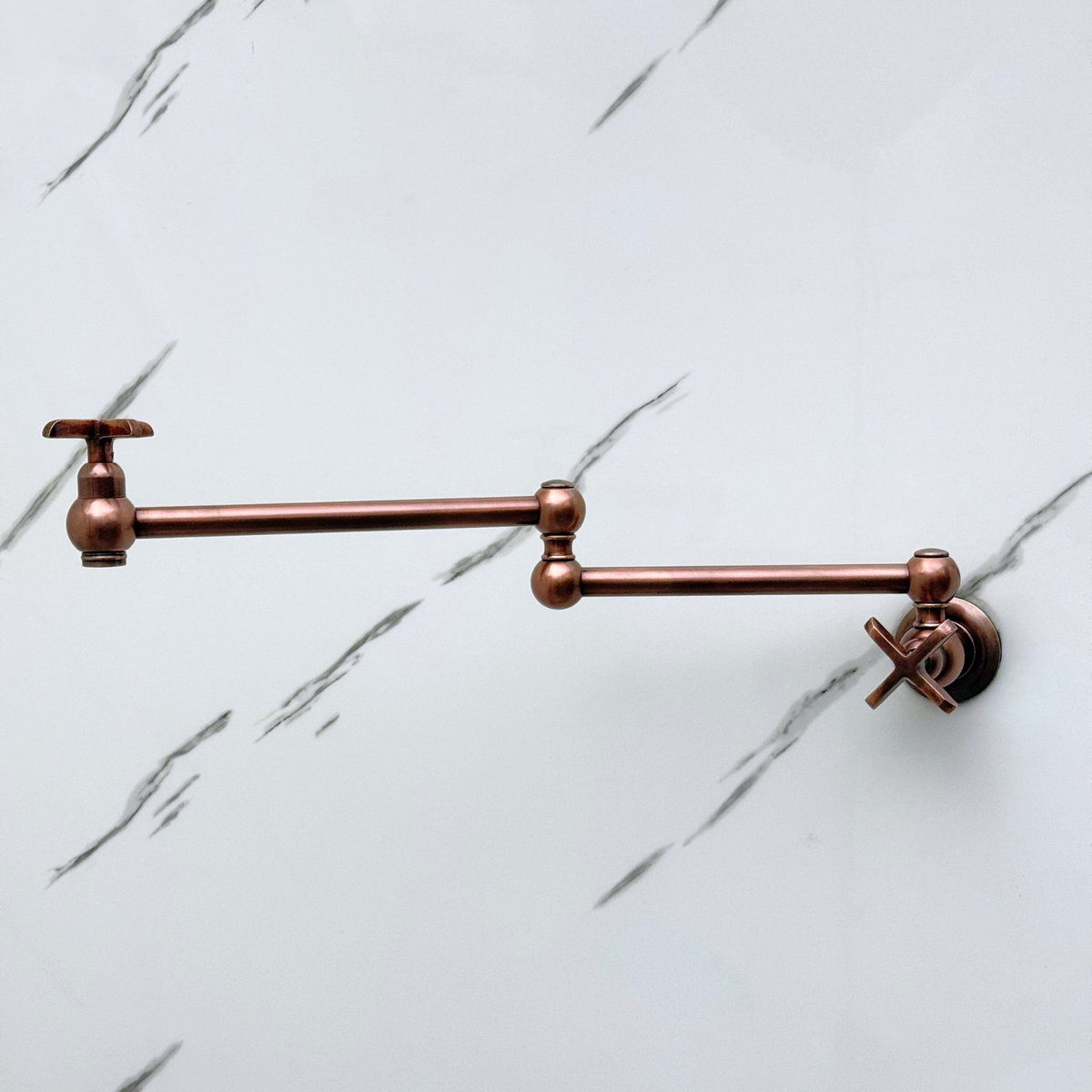 Antique copper wall-mount pot filler shown folded