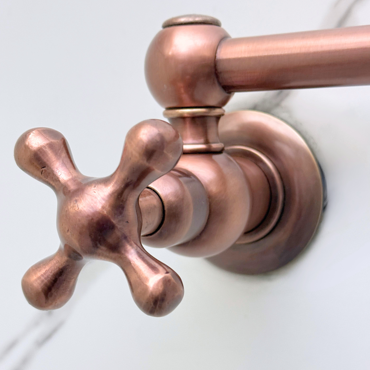 Double-jointed arm on antique copper wall-mount pot filler