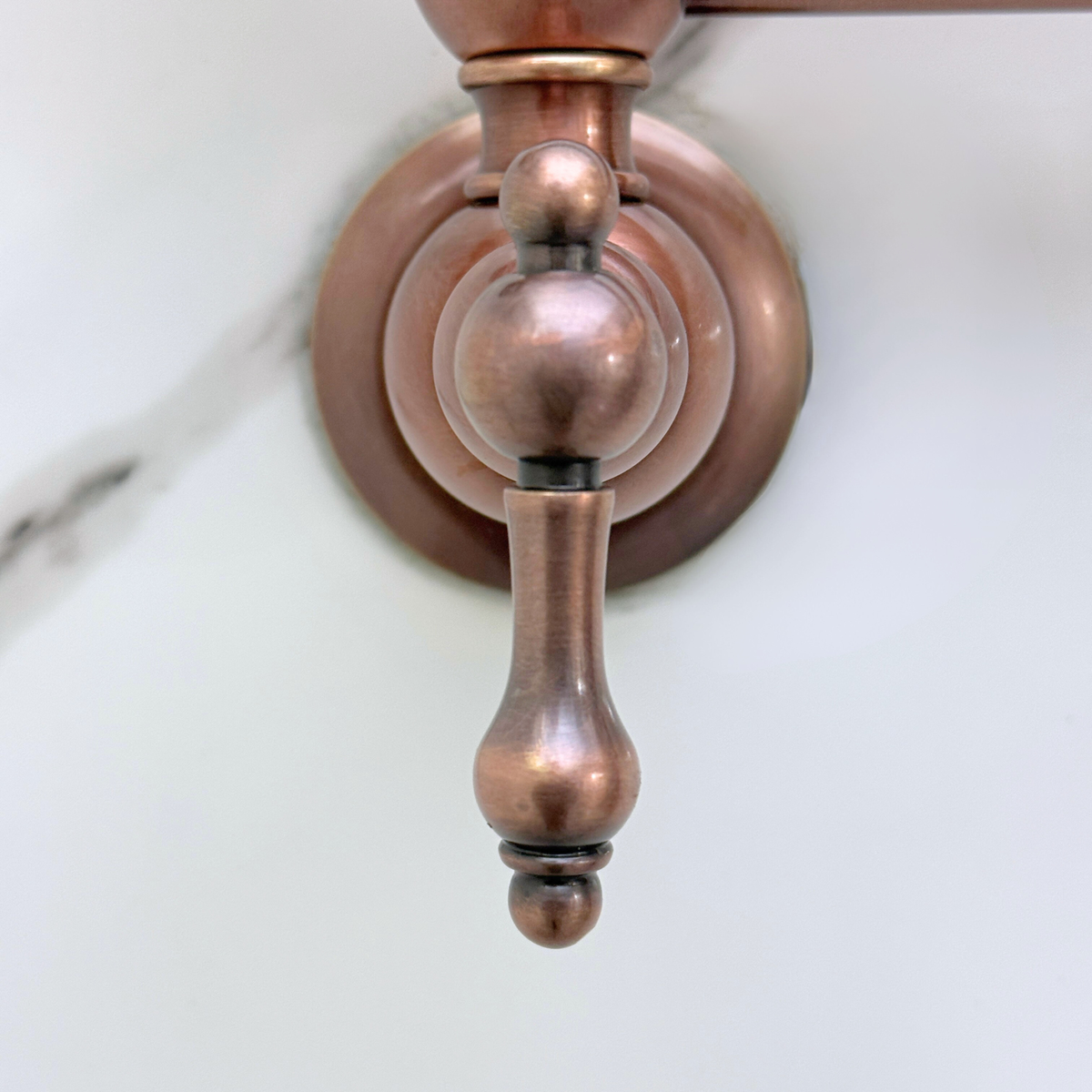 Antique copper wall-mount pot filler shown folded