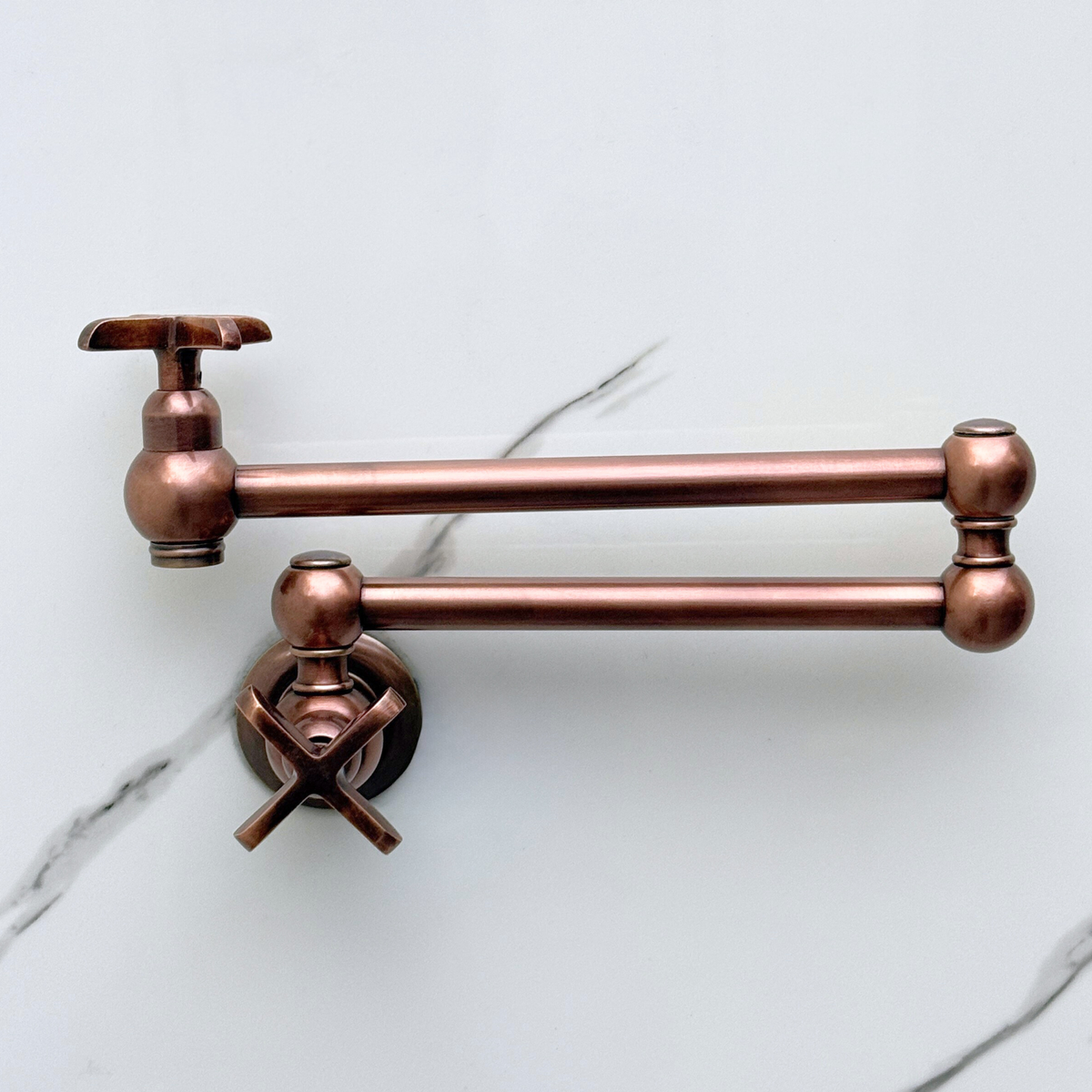 Antique copper pasta faucet shown against kitchen wall