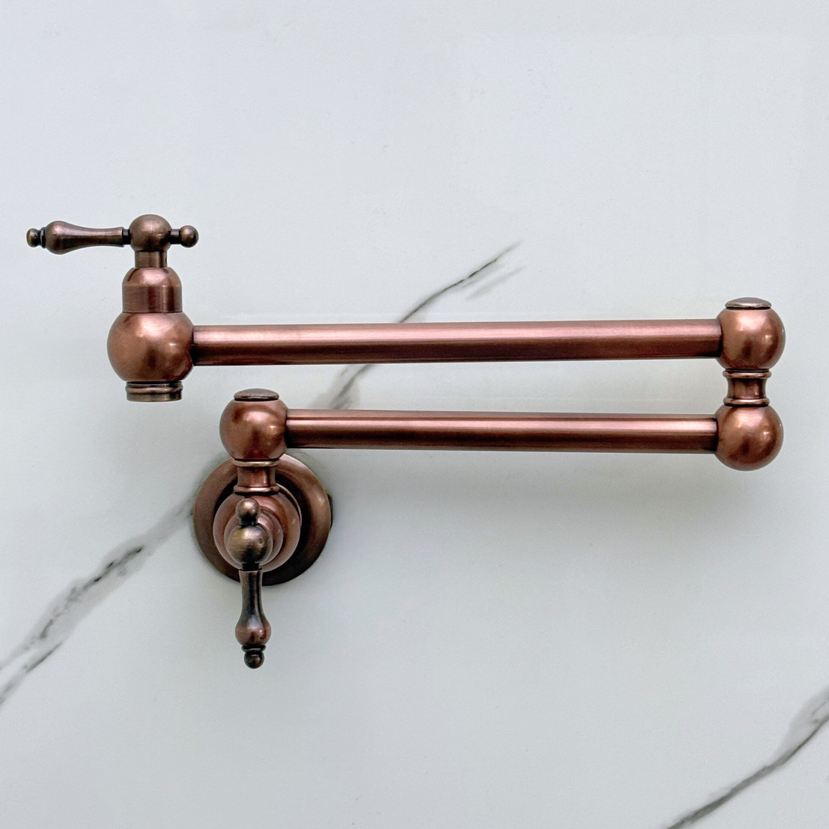 Side view of antique copper pot filler with lever handles