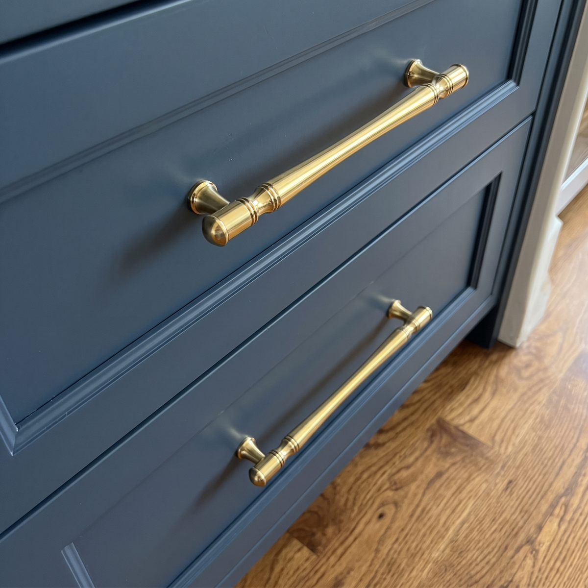 Unlacquered Brass cabinet pulls on blue cabinetry