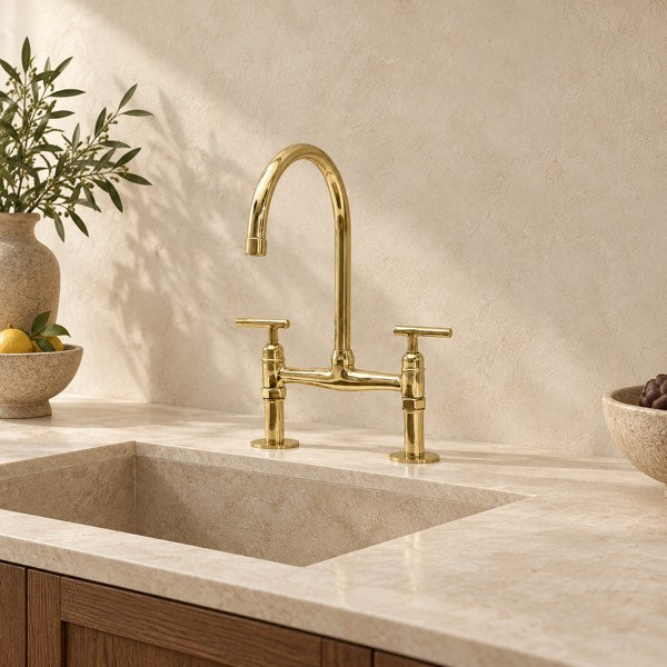 Vintaless brass bridge kitchen faucet in a warm stone kitchen